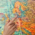 finger pointing the globe