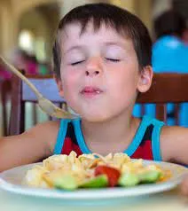 A child enjoying a plate of mac and cheese