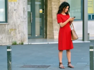 Woman in red dress checking phone, featured in the article 'Beware of 0800 123 0367: What You Need to Know About This Suspicious Number.