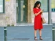 Woman in red dress checking phone, featured in the article 'Beware of 0800 123 0367: What You Need to Know About This Suspicious Number.
