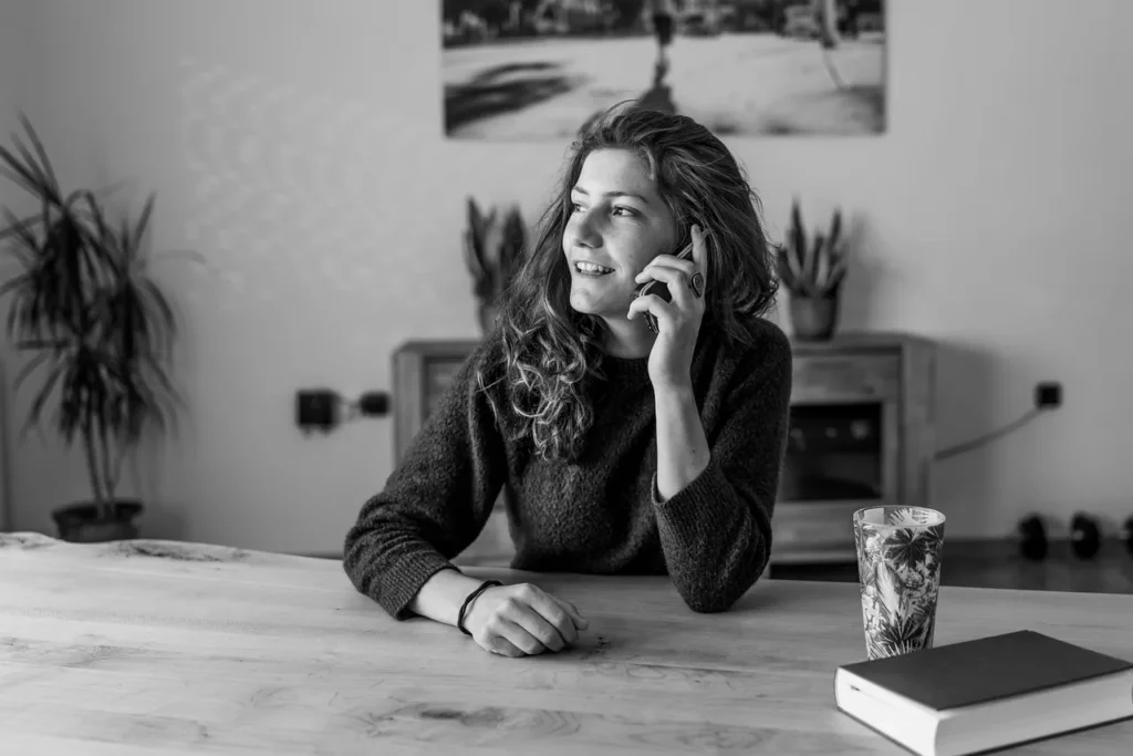 Black and white image of a woman with brown hair talking on a mobile phone, featured in the article 'Who Is Calling From (662) 255-3743? Everything You Need to Know About This Mississippi Number.