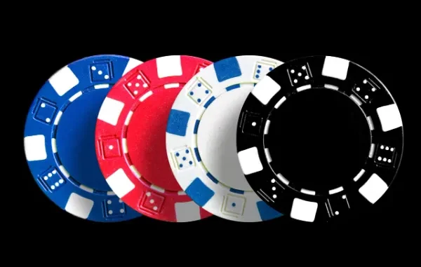 Casino Chips for Online Gaming and Betting A row of four casino poker chips in blue, red, white, and black, featuring dice pips, against a dark background, symbolizing online gambling and betting.