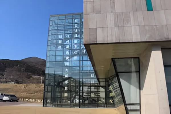 The Hapcheon County Office, a modern building with a blue roof, stands under a clear blue sky, reflecting the tranquility of its rural setting.