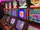 Row of modern slot machines with colorful screens displaying various game themes.