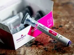 Mounjaro pre-filled injection pen resting against its open product box, displaying the dosage and brand details.