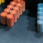 Stacks of red and blue poker chips are neatly arranged on a dark blue surface.