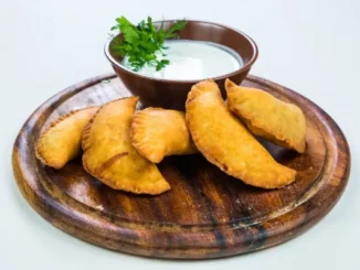 Traditional Colombian breads and savory street-style snacks served on a white plate.