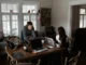 Two women working on laptops on a wooden table, on their small business.