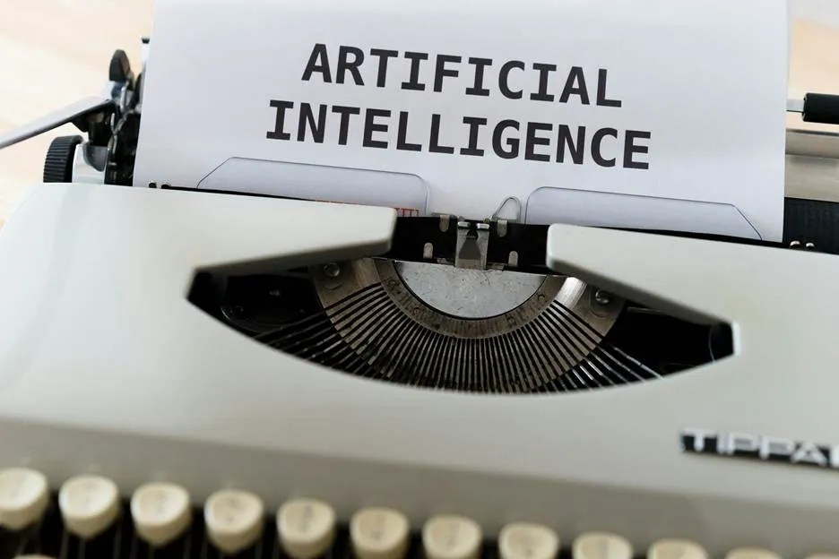 A close-up shot of an antique typewriter with the phrase "ARTIFICIAL INTELLIGENCE" typed on the paper inside.