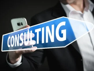A person in a suit holding a smartphone and a blue arrow sign with the word "CONSULTING," symbolizing expert guidance for business solutions.