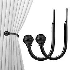 On the left, a matte black U-shaped curtain holdback is shown securing a pleated white curtain. On the right, a pair of identical matte black U-shaped wall-mounted curtain holdbacks are displayed individually against a white background.