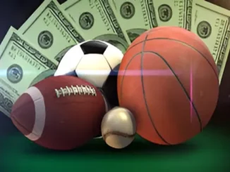 A football, soccer ball, basketball, and baseball in front of fanned-out hundred-dollar bills.