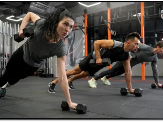 Two people performing a renegade row exercise with dumbbells in a gym, focusing on strength training.