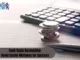 A stack of coins and a pen on a financial document with numbers, alongside a calculator in the background, symbolizing financial calculations and accounting.