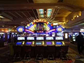 Casino floor with rows of video poker machines under a brightly lit "POKER" sign displaying a progressive jackpot amount.