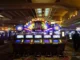Casino floor with rows of video poker machines under a brightly lit "POKER" sign displaying a progressive jackpot amount.