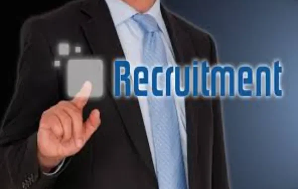 The Digital Evolution of Recruitment: An Overview of Applicant Tracking Systems A man in a suit and tie points to a glowing, transparent screen displaying the word "Recruitment," symbolizing digital hiring processes.