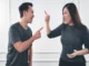 A man and woman angrily yelling and pointing at each other, representing the emotional conflict and distractions that can arise during divorce.