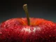 A close-up of a vibrant red apple covered in water droplets, symbolizing freshness, hydration, and healthy nutrition.