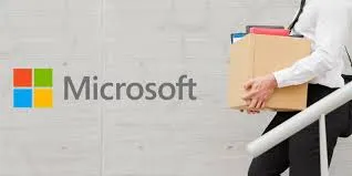 A person in business attire carries a cardboard box of personal belongings down a staircase, with the Microsoft logo prominently displayed on the wall behind them, symbolizing layoffs.