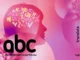 An abstract, vibrant pink and purple image featuring a human silhouette with various letters of the alphabet inside its head, stylized "abc" text, and the word "translate" vertically on the right, symbolizing language and communication.