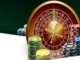 A close-up of a roulette wheel with colorful stacks of casino chips on a red felt table.