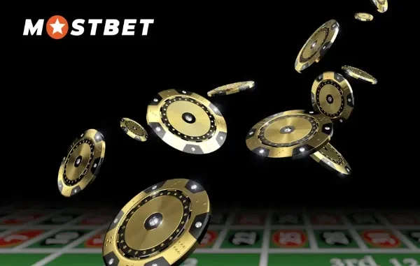 Digitally rendered image of gold and black casino chips in mid-air above a blurred roulette table, with the "MOSTBET" logo visible, representing the element of risk and potential winnings in sports betting.