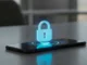 A digital padlock icon glowing above a smartphone screen.