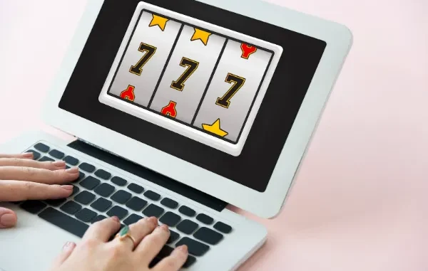 An illustration of a classic slot machine with triple sevens on the reels and gold coins with dollar signs falling around it, representing a jackpot win in online slots.