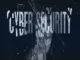 A dark, abstract digital banner with the white text "CYBER SECURITY" overlaid on what appears to be shattered glass or a broken screen, symbolizing digital vulnerability and protection.