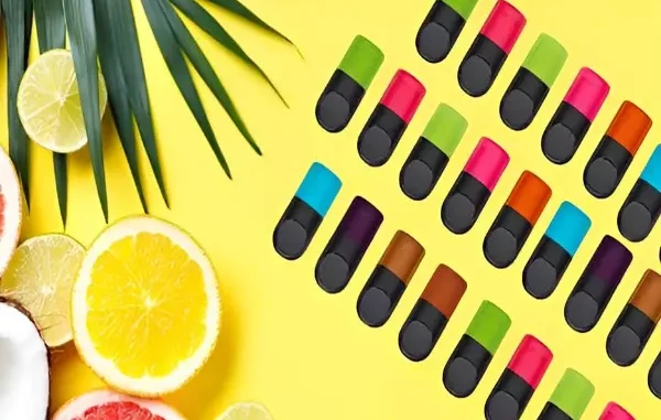A vibrant flat lay of various 2026 trending vape juice bottles—including botanical, 'swicy' mango-habanero, and nostalgic dessert flavors—surrounded by fresh seasonal fruits and mint leaves.