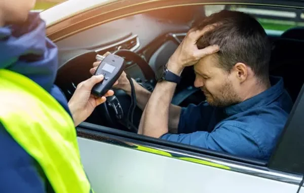 A law enforcement officer conducting a roadside sobriety check on a driver in Dallas, highlighting the legal risks of drugged driving in Texas.
