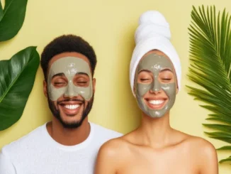 A smiling man and woman with clay face masks applied, framed by tropical green leaves against a soft yellow background, representing a holistic approach to self-care and wellness.