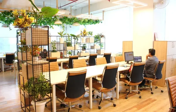 Modern managed office space in Hyderabad featuring ergonomic workstations, glass partitions, and vibrant interior design, illustrating the shift from conventional leasing.