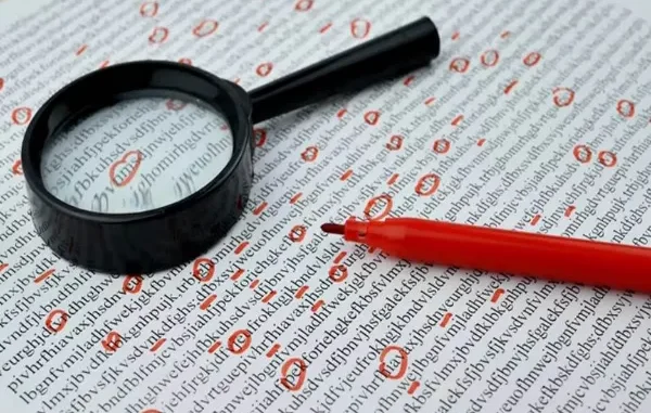 A magnifying glass and a red marker laying on a page of jumbled text with several characters circled in red to represent a manual editing or plagiarism checking process.