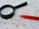 A magnifying glass and a red marker laying on a page of jumbled text with several characters circled in red to represent a manual editing or plagiarism checking process.