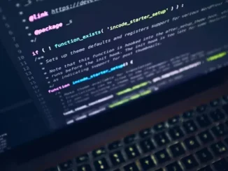 A close-up, angled view of a laptop screen displaying PHP code and syntax highlighting in a dark-themed integrated development environment (IDE).