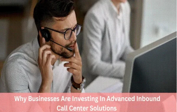 A professional male call center agent wearing a headset and glasses, looking thoughtfully at a computer screen in a modern office environment.