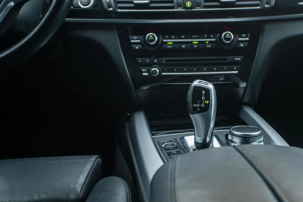 Modern car interior showing the gear shift and dashboard, illustrating an ergonomic driving environment designed to reduce back pain and improve posture during daily travel.