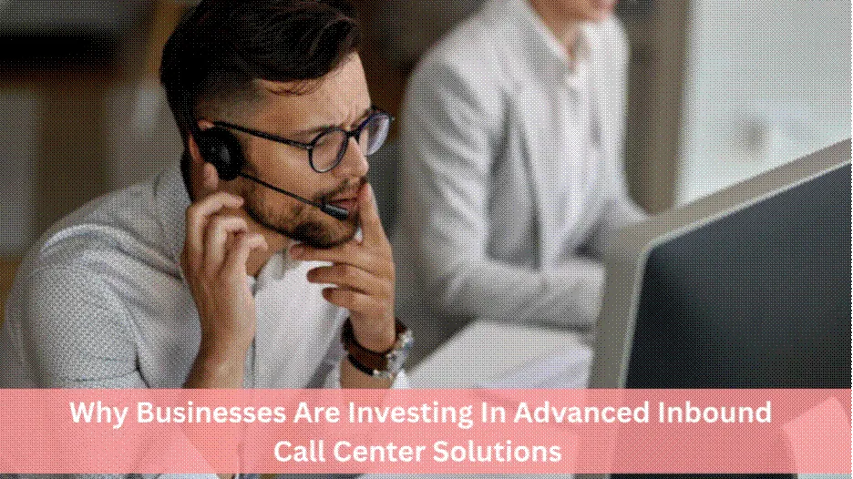 A focused male call center agent wearing a headset and glasses, looking at a computer screen in a modern office setting.