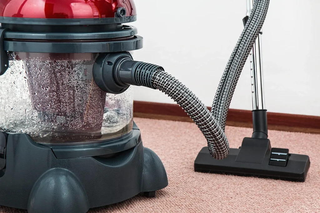 A professional water-filtration vacuum cleaner being used on a carpet during a move-out cleaning in Chicago.