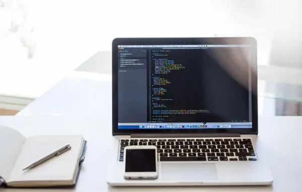 A close-up of a laptop on a wooden desk in a bright, modern office setting, representing a professional upskilling in Generative AI for 2026.