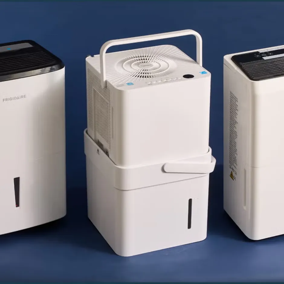 Three different white portable dehumidifiers standing side-by-side against a blue background, showing various tank sizes and vent designs.