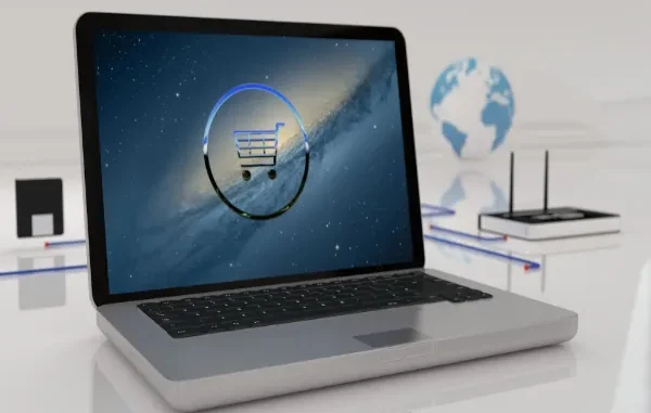 A 3D rendering of an open laptop featuring a glowing blue shopping cart icon inside a circle on the screen, set against a background with a globe and networking equipment to represent global digital commerce.