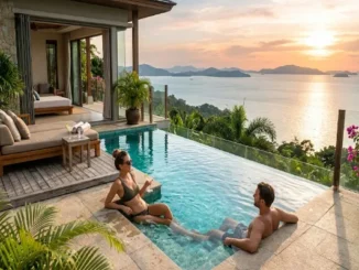 A couple relaxing in an infinity pool at a luxury villa at sunset, overlooking a tropical ocean bay and lush islands.