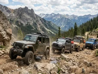 A convoy of equipped off-road vehicles, including a Jeep Wrangler, Toyota Tacoma, Land Rover Defender, and Ford Bronco, navigating a steep, rocky mountain trail under a cloudy sky.