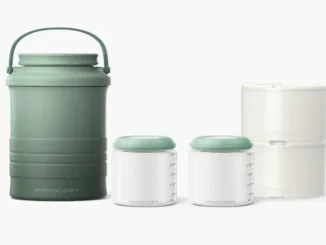 A Momcozy portable breast milk cooler system against a white background, featuring a tall sage green insulated thermos with a handle, two clear glass baby bottles with green lids containing milk, and two stackable white ice packs.