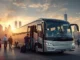 Passengers with luggage boarding a modern, luxury silver charter bus with a city skyline at sunset, illustrating luxury group travel options for Omaha.