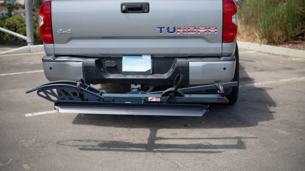 Folding platform hitch bike rack mounted to the receiver hitch of a silver pickup truck.