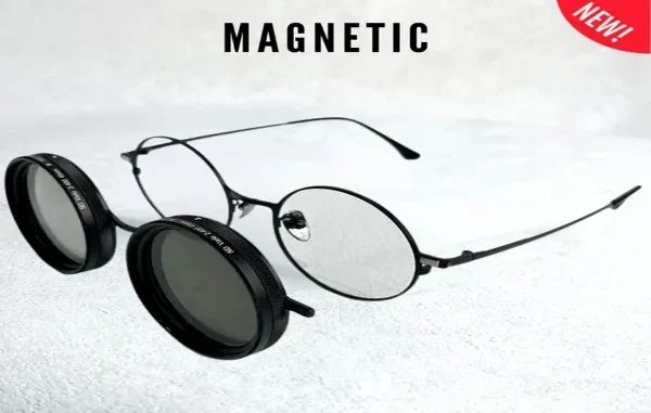 Round black-rimmed eyeglasses with a matching magnetic clip-on sunglass attachment hovering to the side to demonstrate how they snap on.